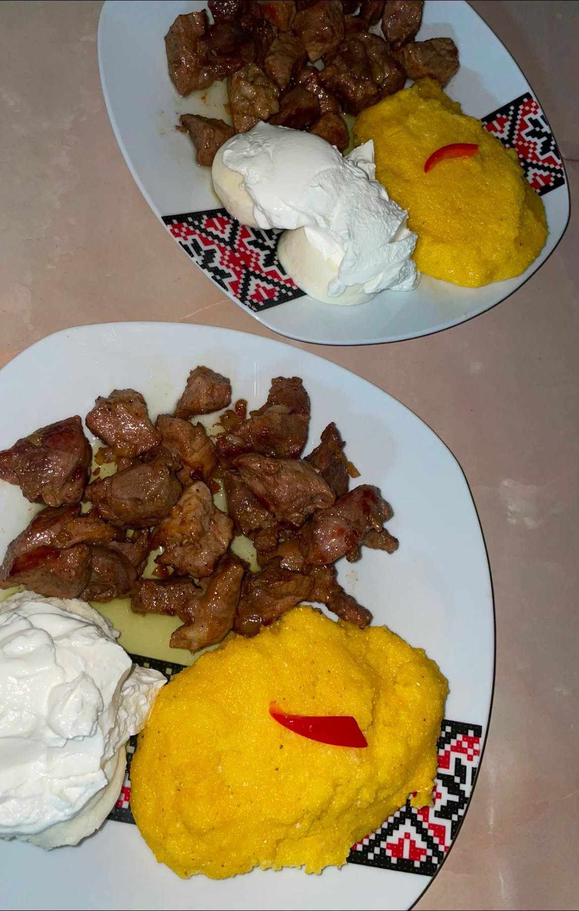 Tochitură de porc cu mămăligă și ou, servită în vas de lut